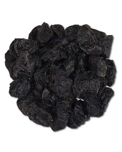 Dried pitted prunes in a pile, showcasing their deep purple hue and chewy texture, perfect for birds or snacking.