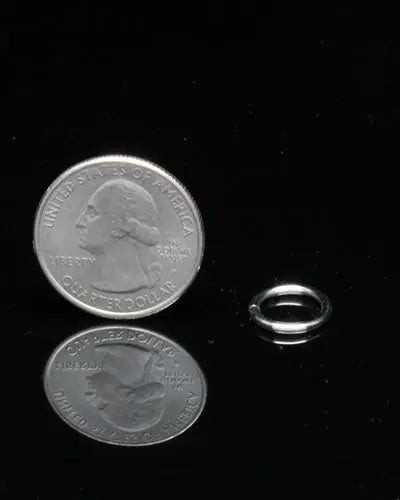 Close-up of a 3/8" split ring, a small, durable metal hardware piece for bird toys, showcasing its 1/2" diameter and sleek design.