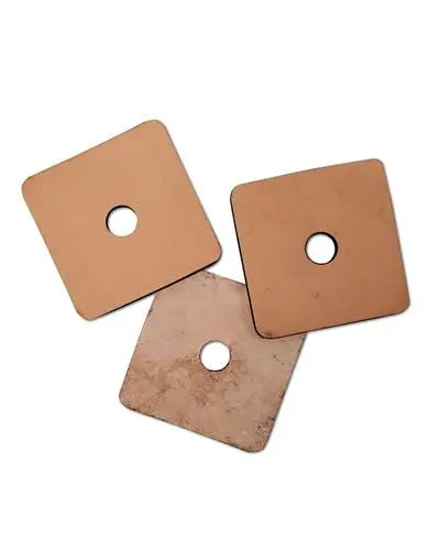 Close-up of three 2x2 inch vegetable-tanned leather squares, natural and bird-safe, with small center holes for toy-making.