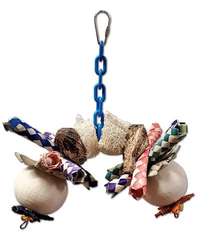 Colorful bird toy with natural pods, loofah slices, finger traps, and woven palm leaves, hung horizontally for play.