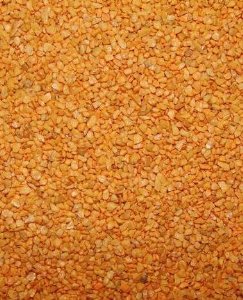 Vibrant orange apricot granules in bulk, perfect as a wholesome, tasty treat for birds with a naturally sweet appeal.