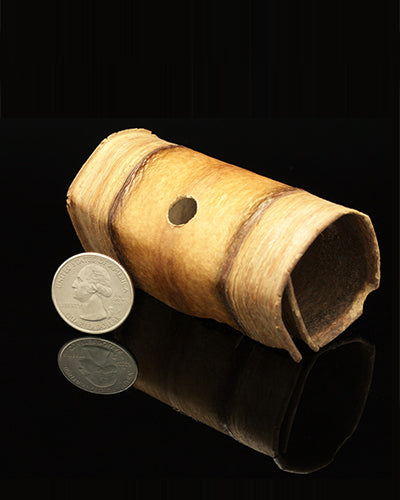 Close-up of a Banana Roll, a 3.5-inch long, natural toy part with a curved, textured shape and earthy tones.