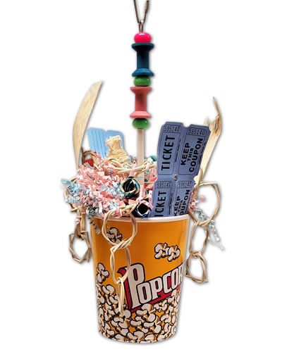 Vibrant bird toy with a popcorn box overflowing with corn cob, woven vines, shredded paper, and real ticket stubs for playful fun.